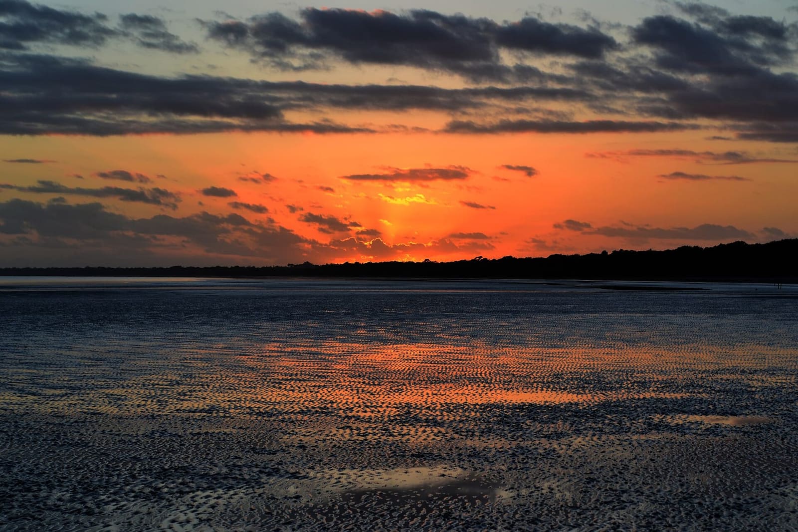 Fiery orange sunset over dark water in the Great Sandy Marine Park