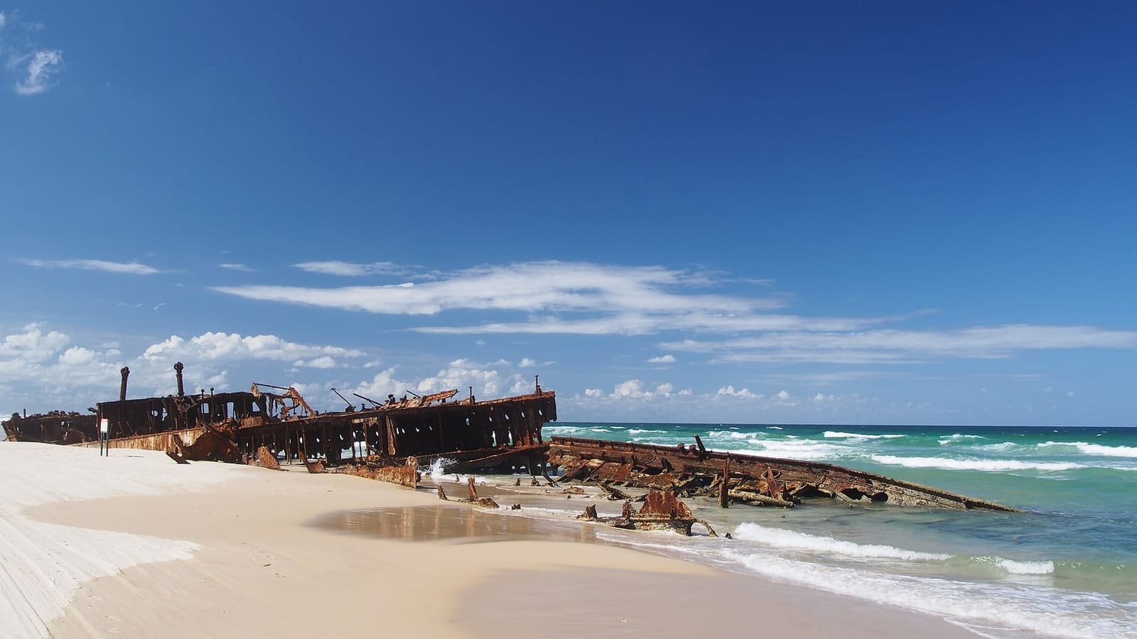 The rusting wreck of the SS Maheno on the white sand of K'gari's eastern beach