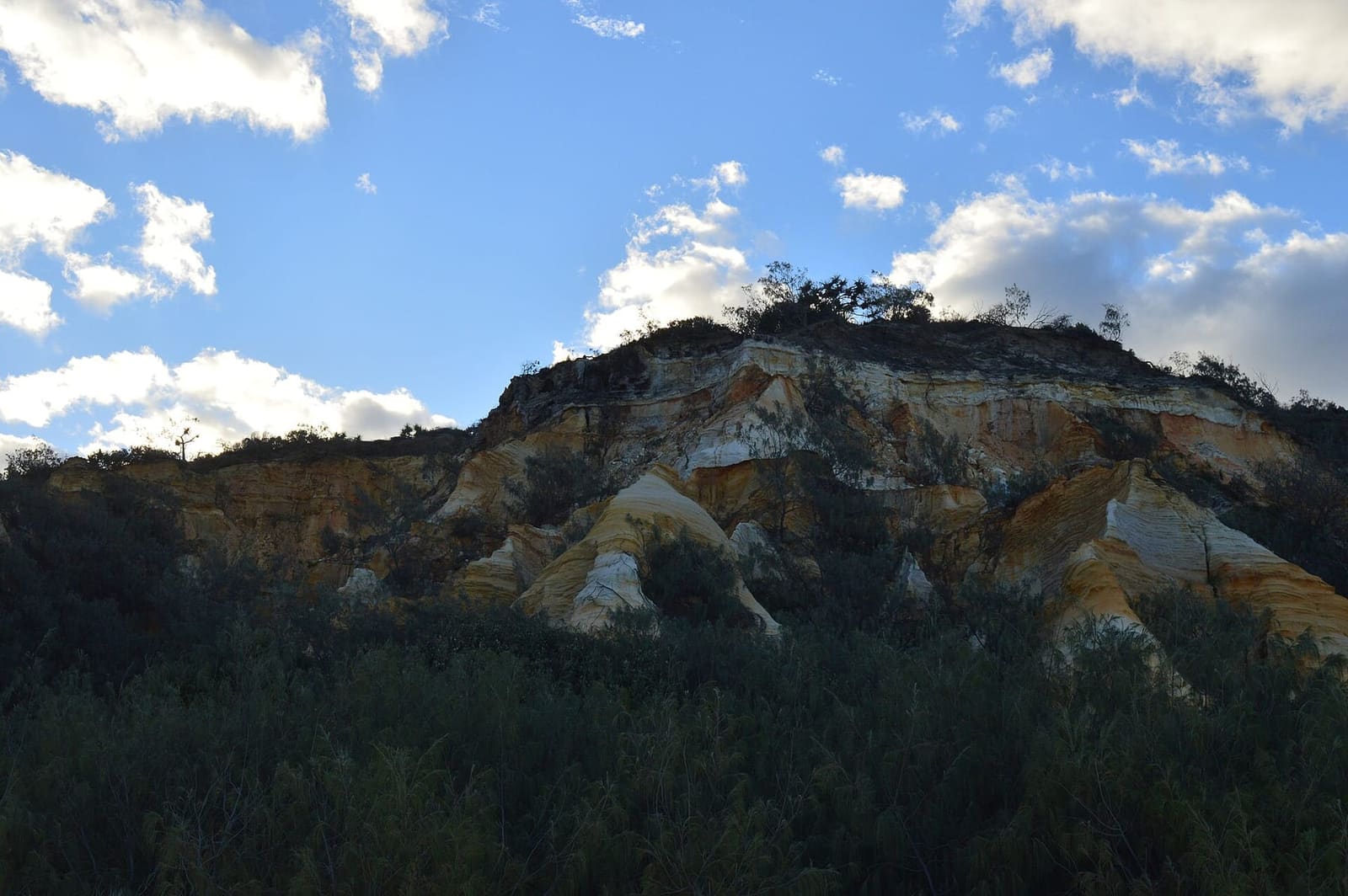 The Pinnacles: ochre and cream coloured-sand cliffs under a blue sky on K'gari